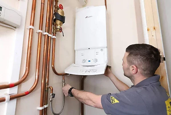 Professional engineer performing power flushing on boiler system